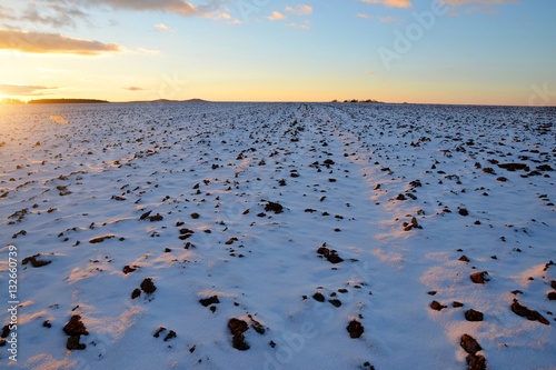 Winter landscape with snowy field at sunset.
