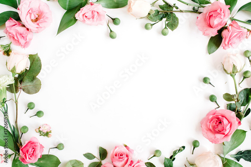 Fototapeta Naklejka Na Ścianę i Meble -  Round frame made of pink and beige roses, green leaves, branches on white background. Flat lay, top view. Valentine's background