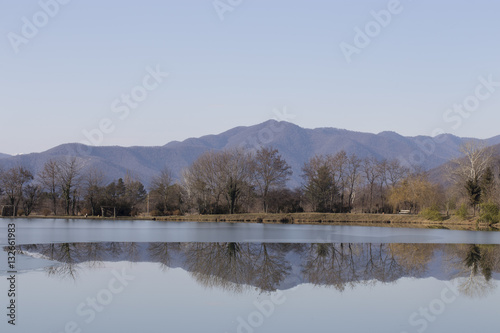 Trees and mountains reflected in the lake.