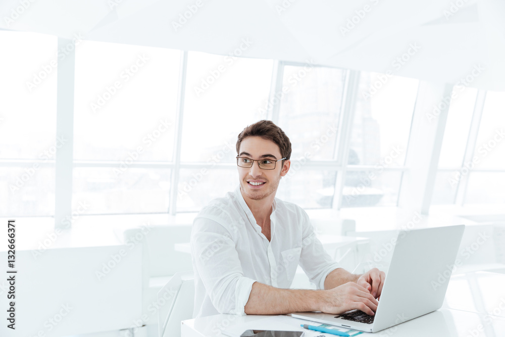 Smiling young man using laptop computer. Smiling young man using laptop computer.