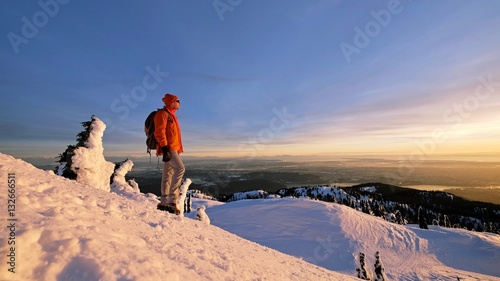 Man snowshoeing on mountain top watching sunset. Mount Seymour Provincial Park. Vancouver. British Columbia. Canada. photo