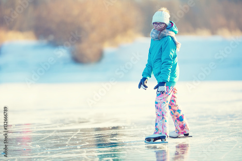 Принти на полотні Ice skating. Young girl is skating on a natural frozen lake.