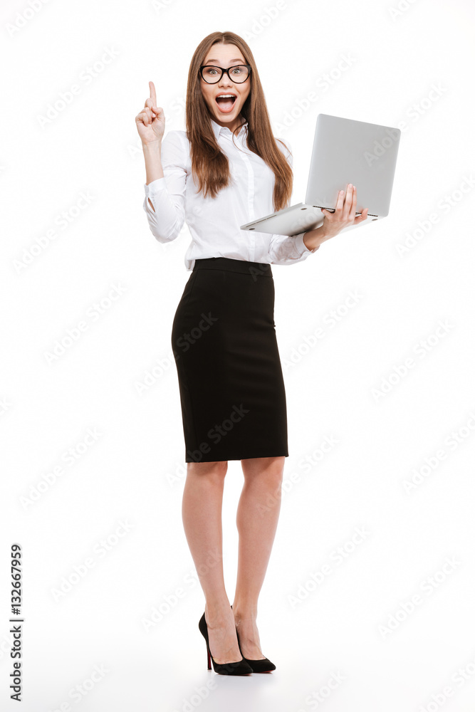 Business woman standing with laptop and pointing finger up Business woman standing with laptop and pointing finger up