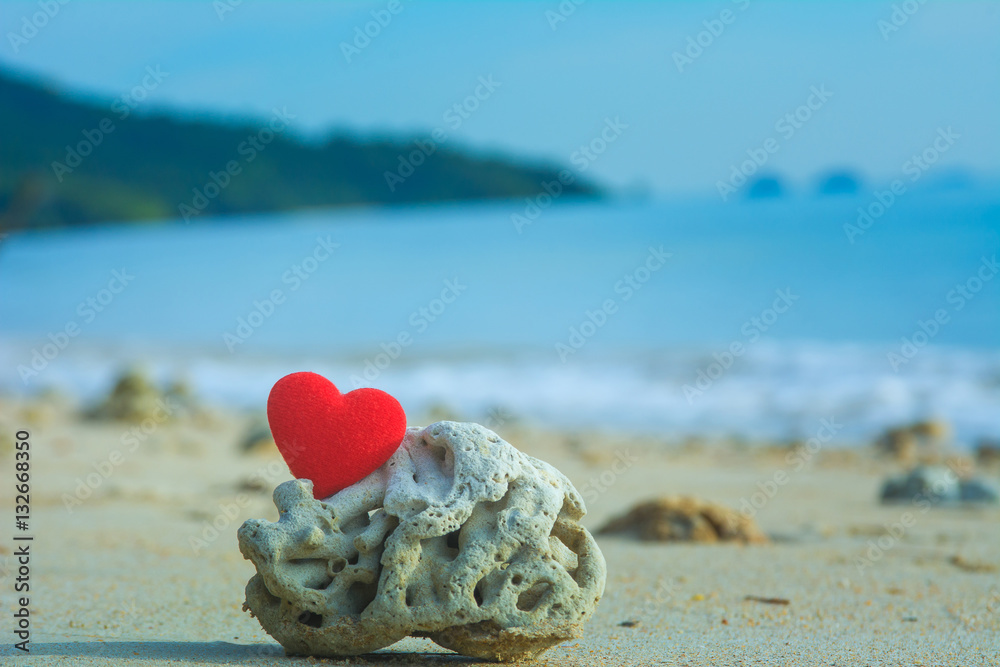 red heart on coral beach with blue sea background red heart on coral beach with blue sea background
