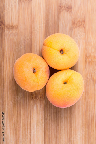 Whole ripe apricots isolated on a wood background