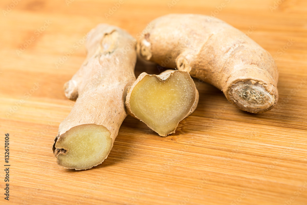 Sliced ginger root with a heart shape isolated on a wood background