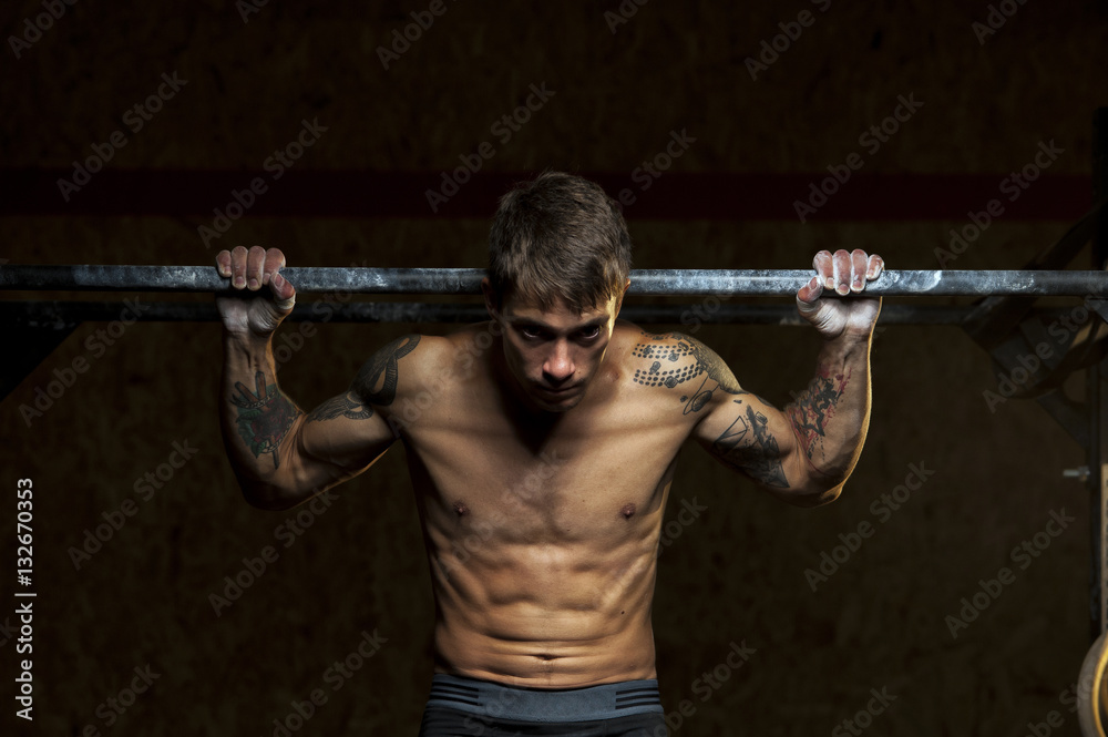 Muscular male athlete doing pull up exercise Muscular male athlete doing pull up exercise