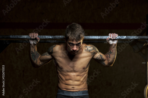 Muscular male athlete doing pull up exercise © pavel_shishkin
