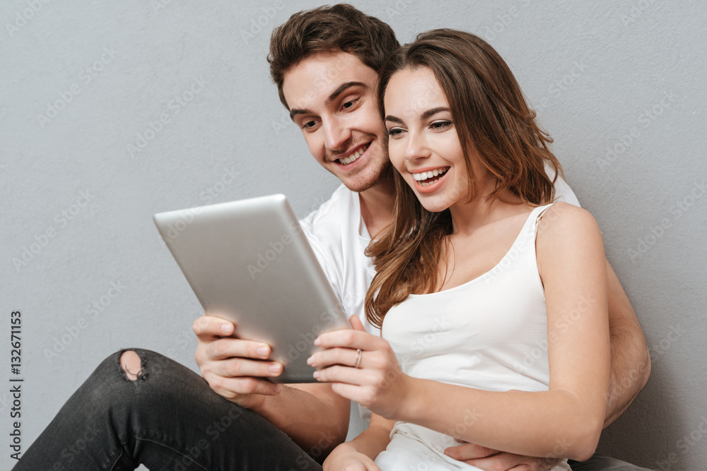 Couple using tablet computer on the floor Couple using tablet computer on the floor