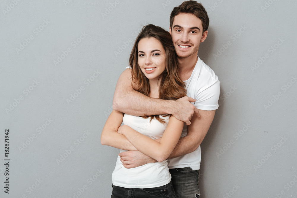 Couple standing in studio posing with hands in pockets - Stock Image -  Everypixel