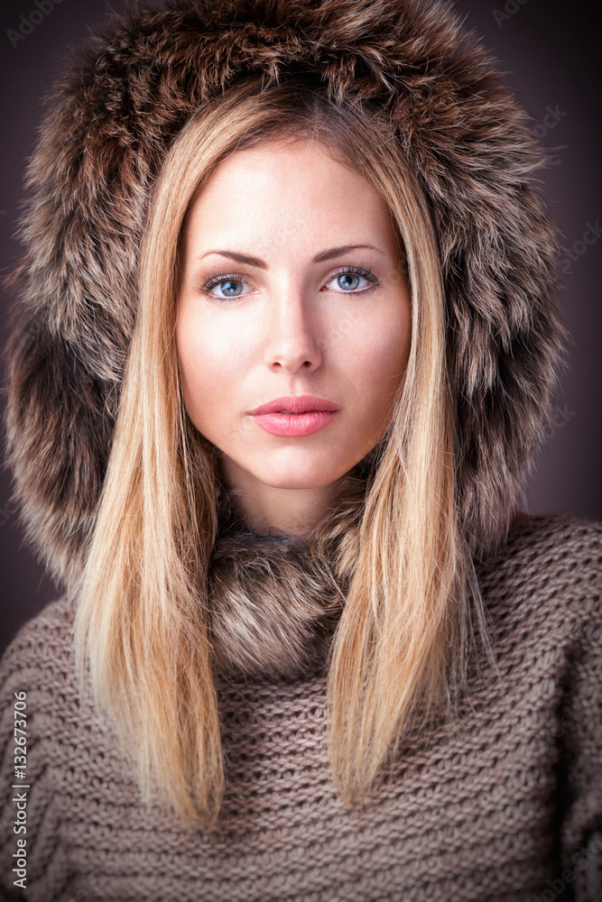 Blondes Model mit Strickpullover und Fellkapuze Blondes Model mit Strickpullover und Fellkapuze