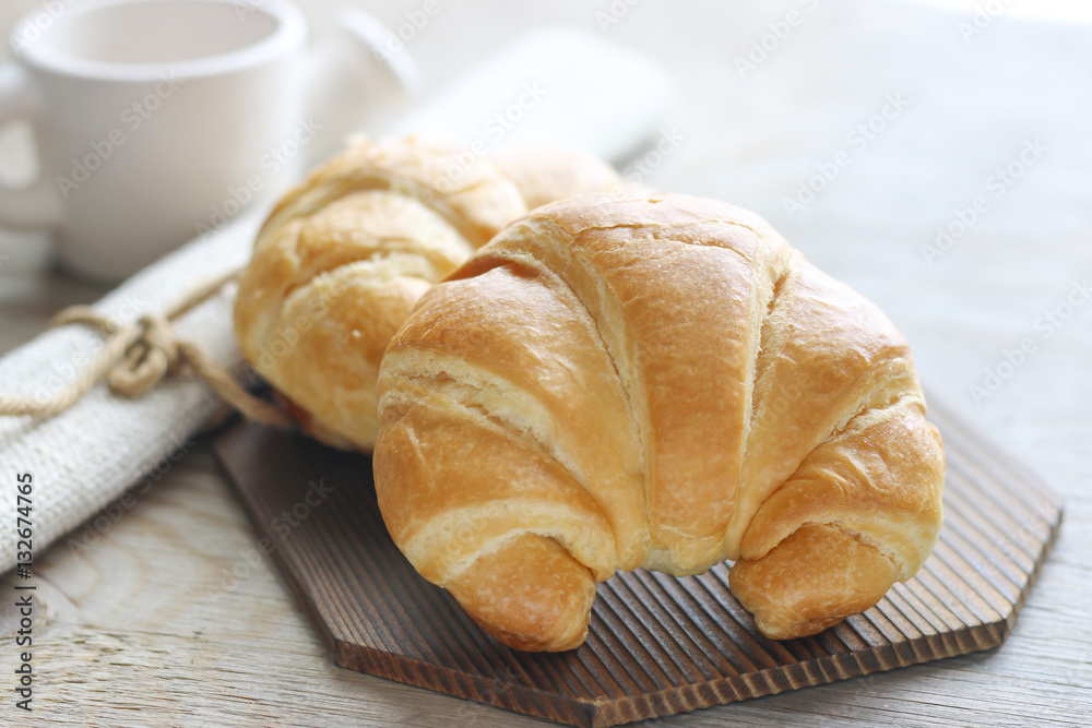 Stock Photo:.Fresh and tasty croissant on old wooden table