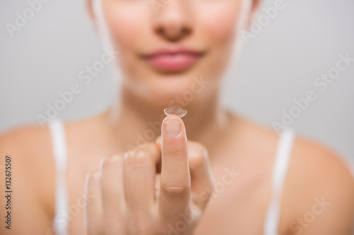 Fototapeta Naklejka Na Ścianę i Meble -  Woman holding contact lens