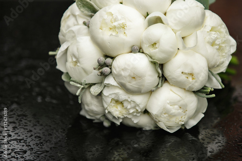 Fototapeta Naklejka Na Ścianę i Meble -  Peony bouquet, white peonies on black table with raindrops in rainy weather. Beautiful bouquet of fresh flowers