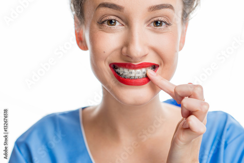 Close up portrait of smiling woman with tooth braces. Studio shot on the white background