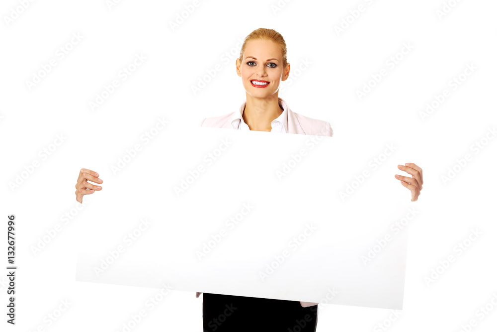 Smiling young businesswoman holding blank banner Smiling young businesswoman holding blank banner