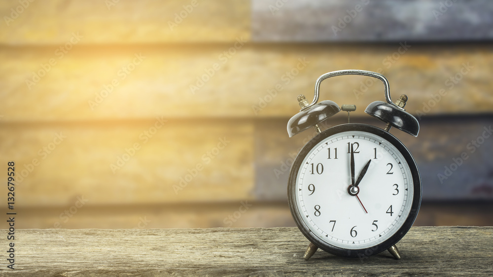 Black alarm clock on a wooden table. Black alarm clock on a wooden table.