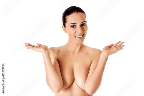 Topless woman covers her breasts with hands.