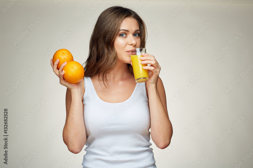 sporty woman drink orange juice and holds fruit. isolated studio portrait. sporty woman drink orange juice and holds fruit. isolated studio portrait.