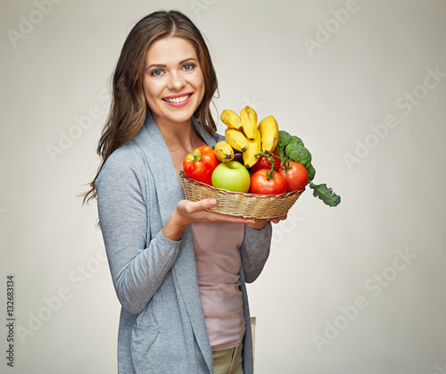 Smiling young woman holding fruit set.