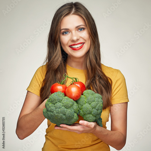 toothy smiling young woman holding vegetabless. photo