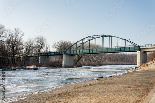 Frozen river with ice and bridge