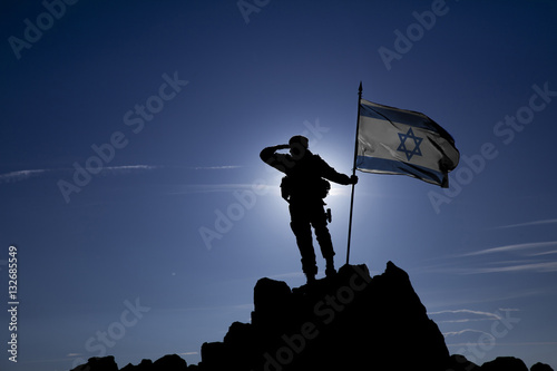 Soldier on top of the mountain with the Israeli flag photo