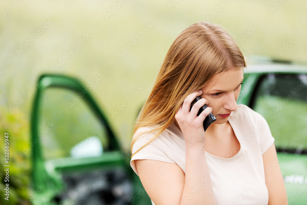 Fototapeta premium Female driver making phone call after traffic accident