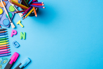 Overhead shot of school supplies on blue background