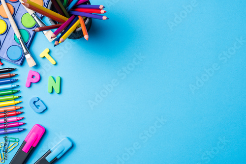 Overhead shot of school supplies on blue background photo