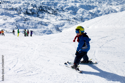 Two young children, siblings brothers, skiing in Austrian mounta