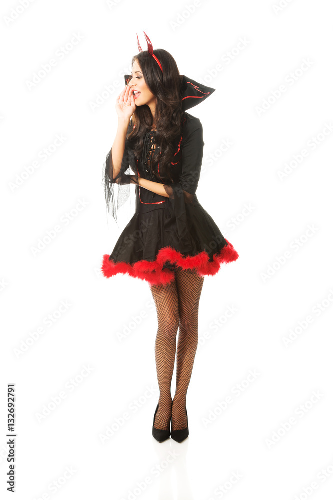 Full length woman wearing devil clothes whispering to someone Full length woman wearing devil clothes whispering to someone
