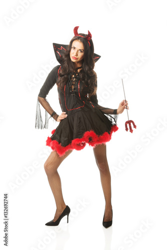 Sexy woman wearing devil clothes, standin astride, holding trident