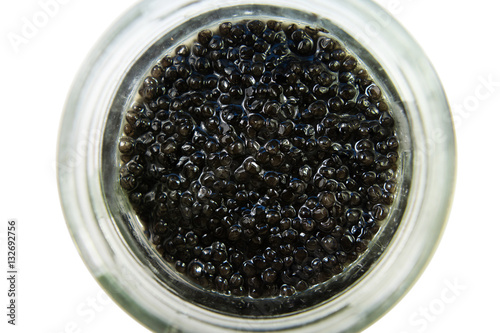 Black caviar in a glass jar. Top view isolated on white background