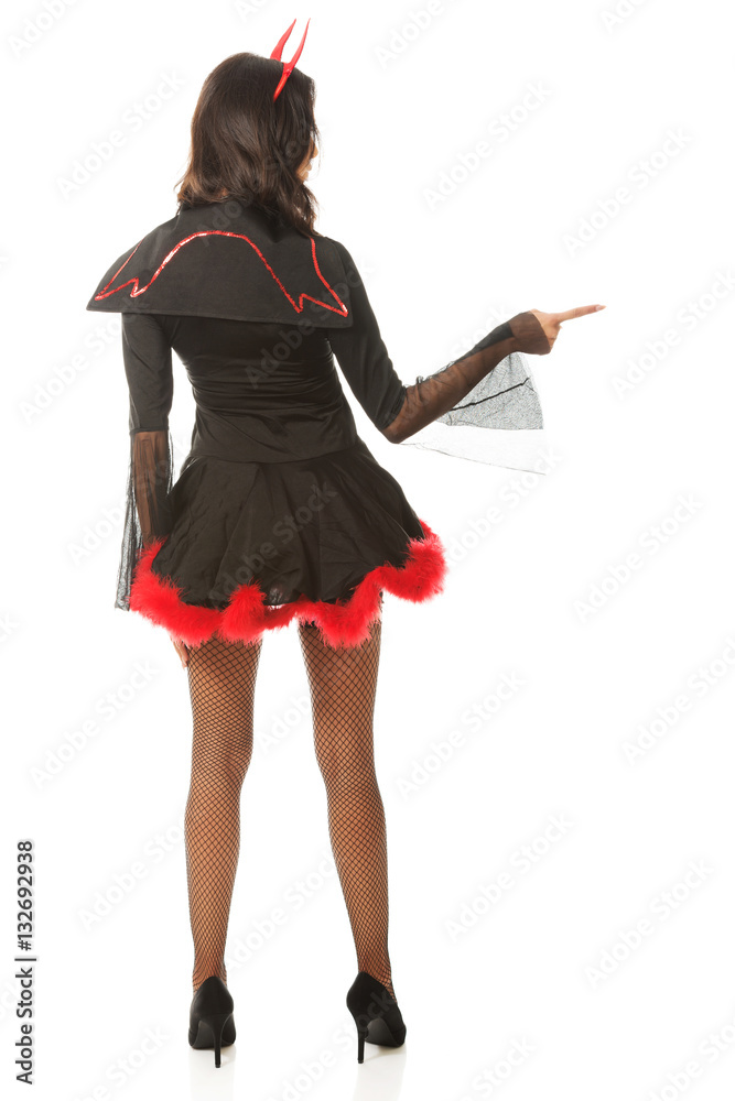 Back view of woman pointing right wearing devil clothes Back view of woman pointing right wearing devil clothes