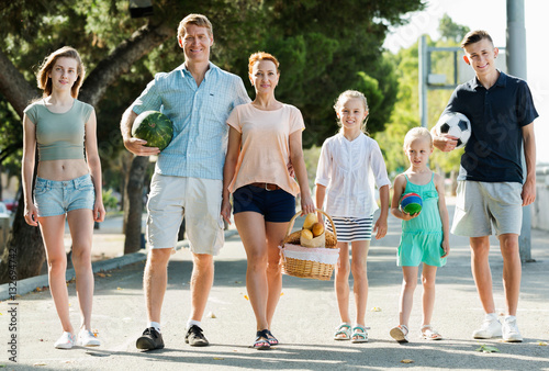 Man and woman with four kids smiling and taking walk