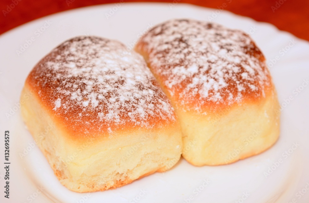 Sweet baked homemade buns powdered with sugar.