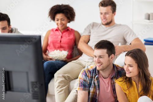 happy friends watching tv at home