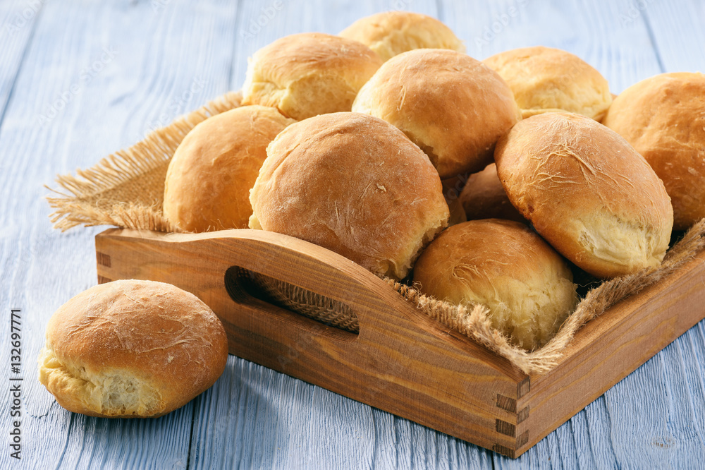 Homemade potato bread roll on wooden tray.