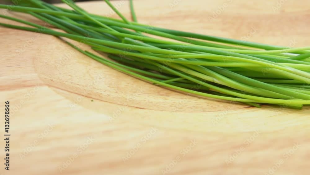 sliced green onions on a wooden board with a special knife sliced green onions on a wooden board with a special knife