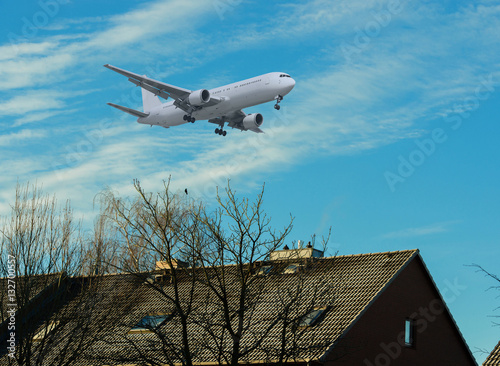 Flugzeug im Landeanflug über einem Wohngebiet