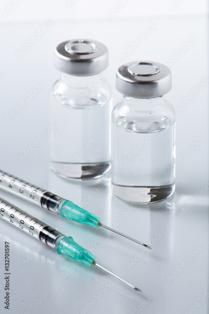 medical ampoules and syringe on White background