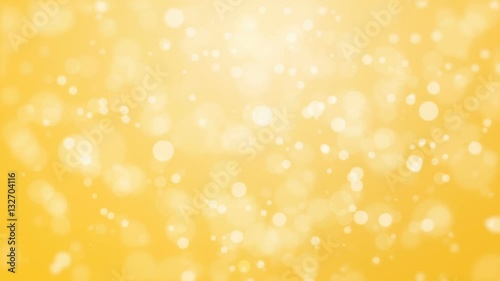 Cheerful golden yellow bokeh background with floating glowing lights.