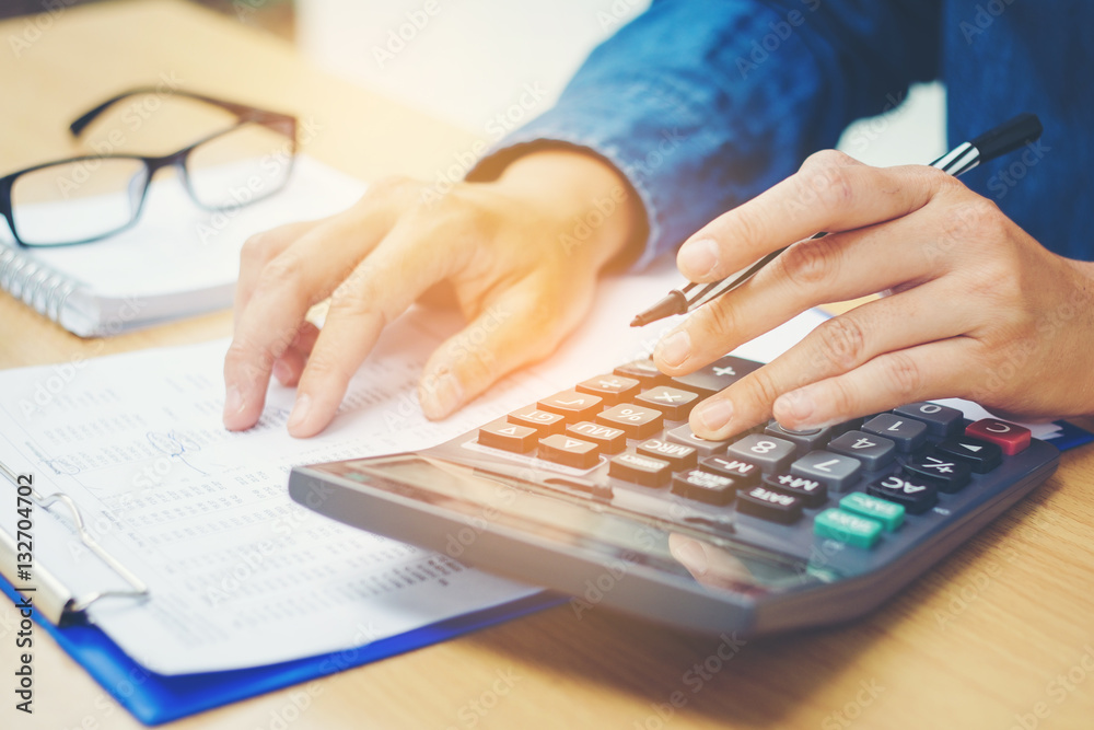 Financial data analyzing hand writing and counting on calculator Financial data analyzing hand writing and counting on calculator