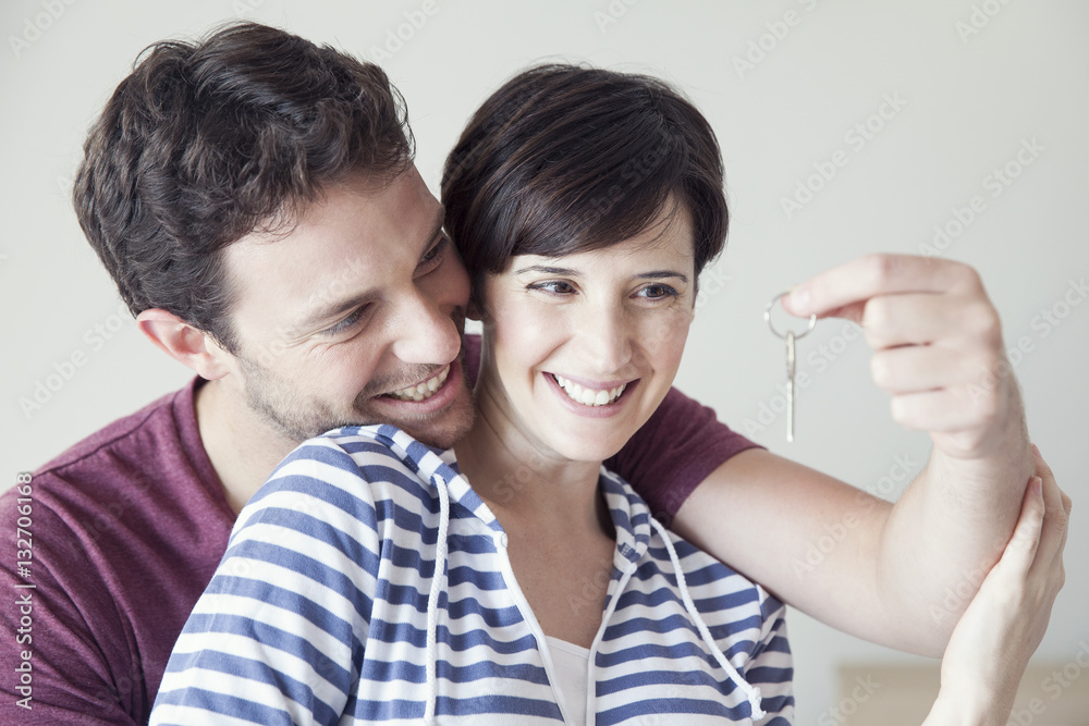 Couple looking cheerfully at house key together Couple looking cheerfully at house key together