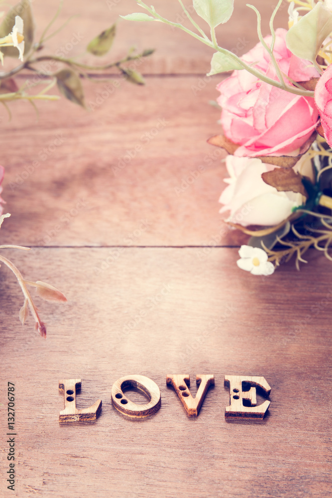 Word Love with rose flower on wood table, Valentine's Day background