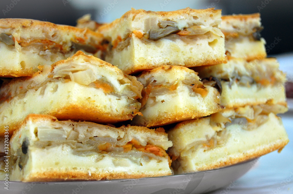 Pieces of sliced homemade pie with cabbage and carrot, stacked on each other closeup. Pieces of sliced homemade pie with cabbage and carrot, stacked on each other closeup.