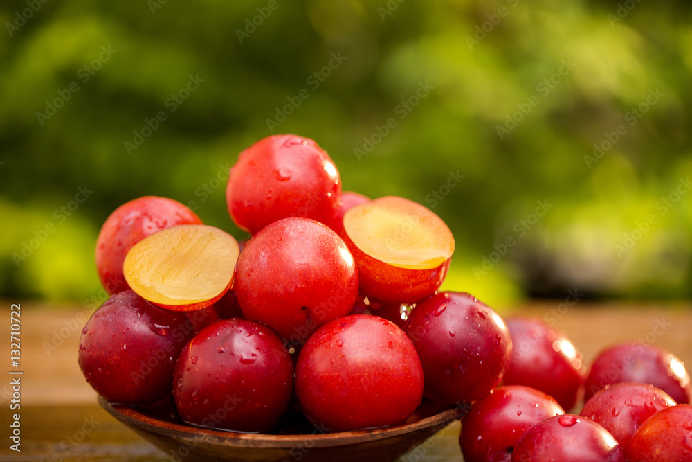 Fresh bright plums on wooden background