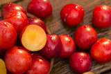 Fresh bright plums on wooden background