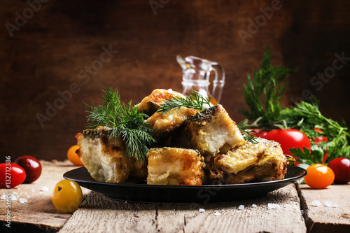 Bild auf Leinwand Fried fish, pieces of mullet with dill on a plate. Vintage woode